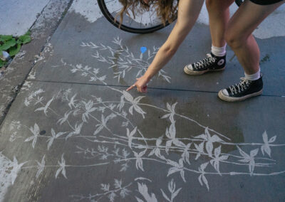 Une jeune femme montre du doigt la plante dessinée sur le sol mouillé